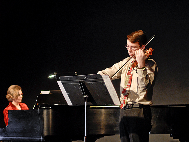 student playing violin in performance