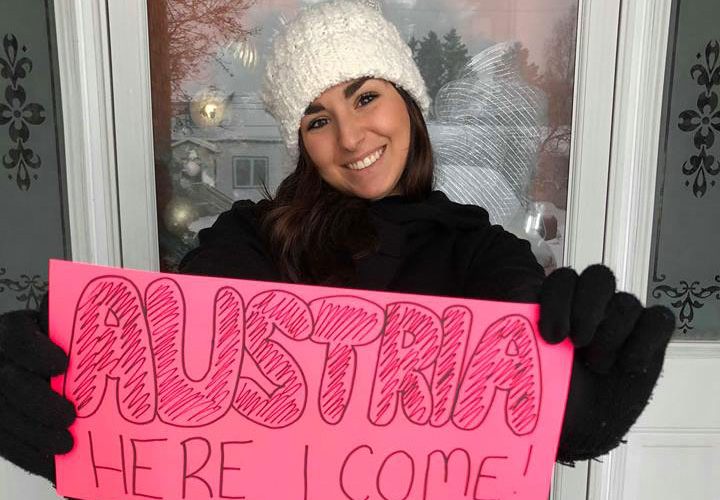 student holding austria here i come sign