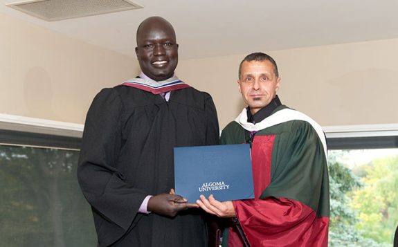 registrar handing diploma to student
