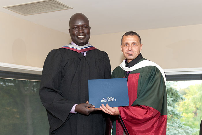 registrar handing diploma to student