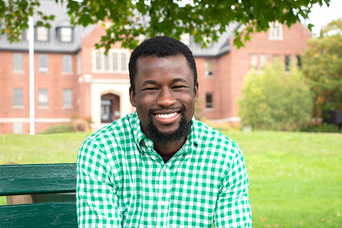 student smiling on park bench