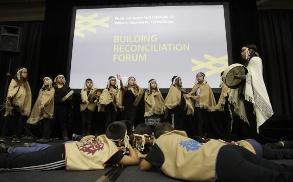 students performing on stage at building reconciliation forum