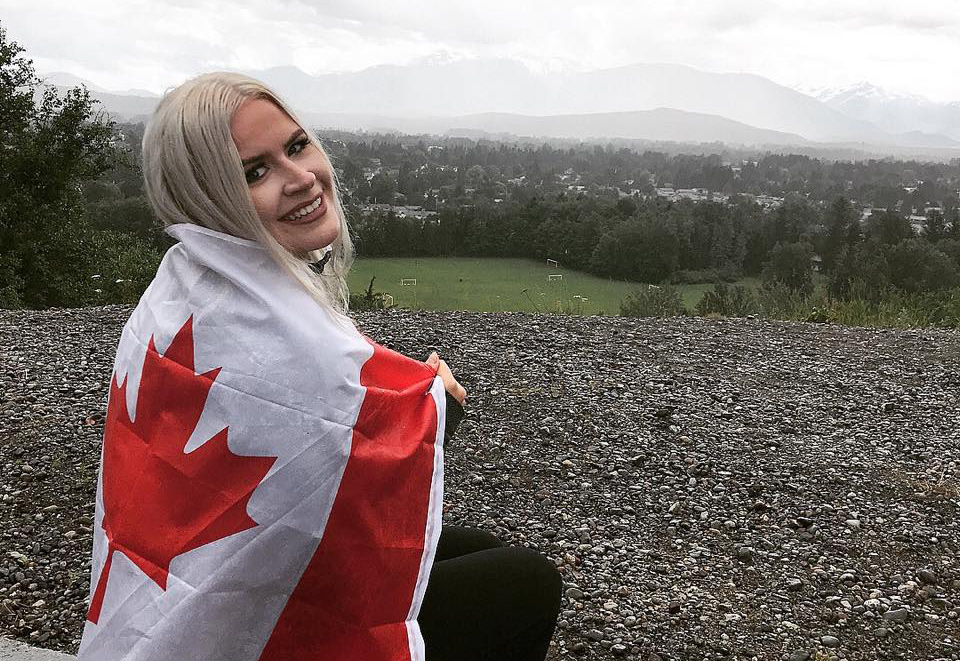student headshot in other country wrapped in Canadian flag