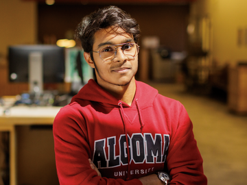 student smiling in Algoma University sweater
