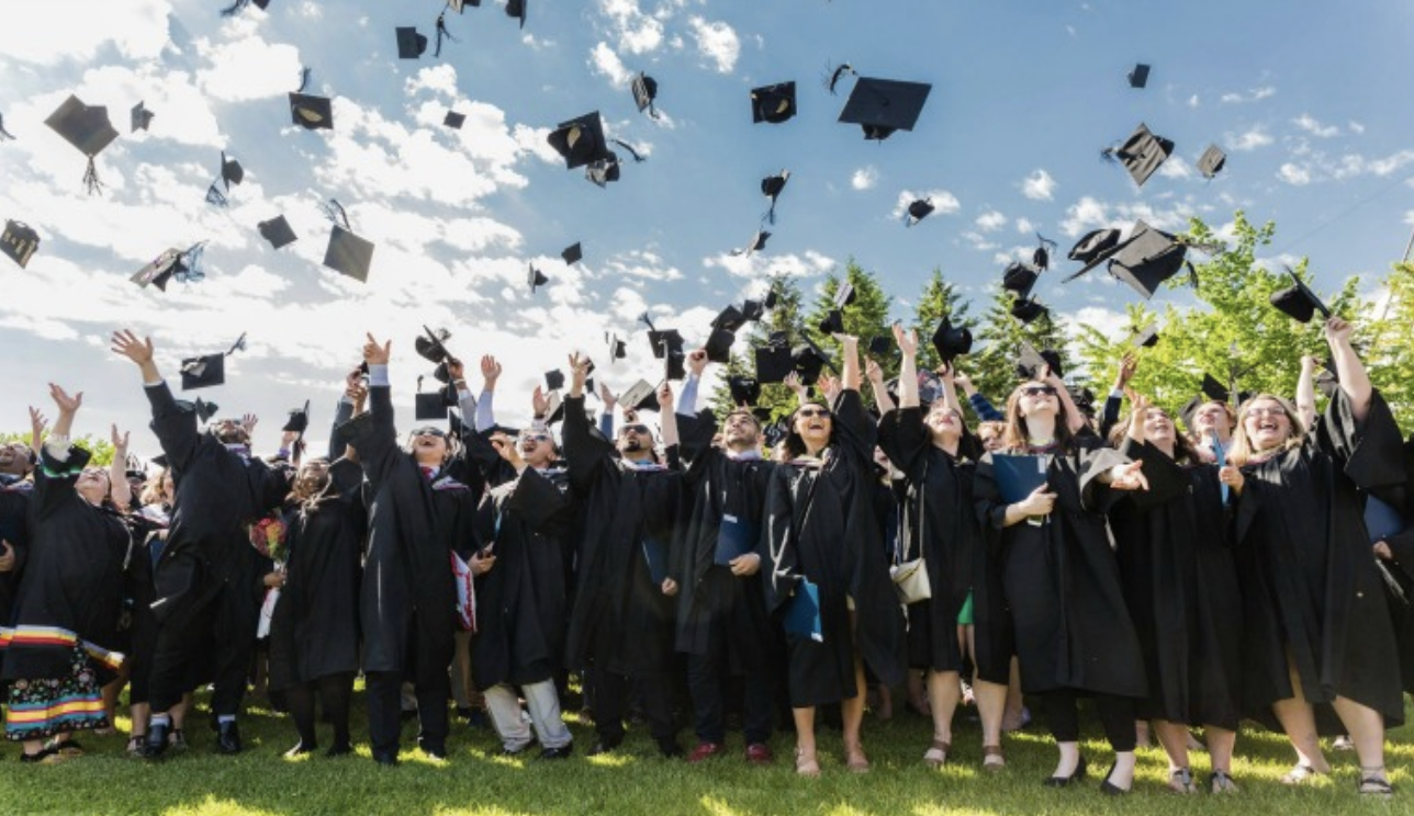 Graduates throwing cap in air on graduation day