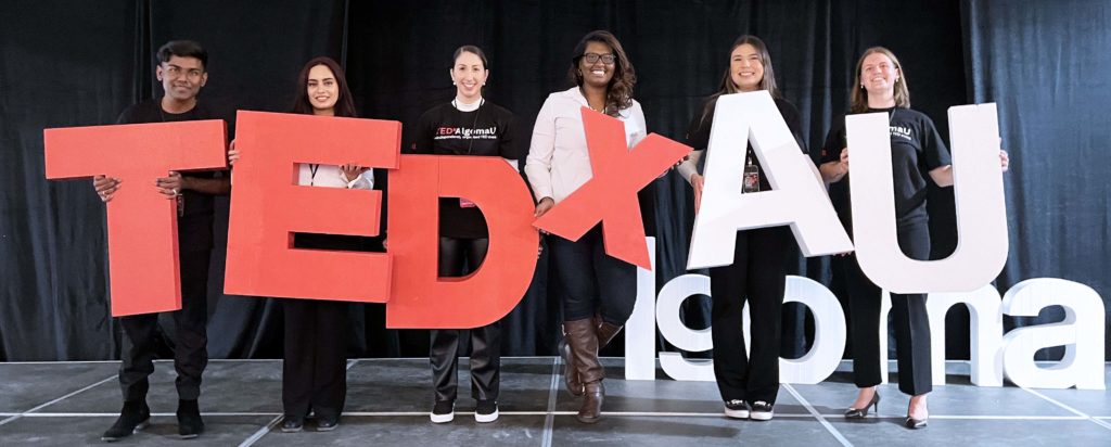 TEDxAlgomaU team holding letters