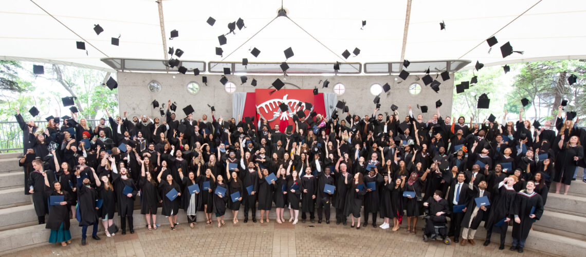 Group shot of grads throwing caps